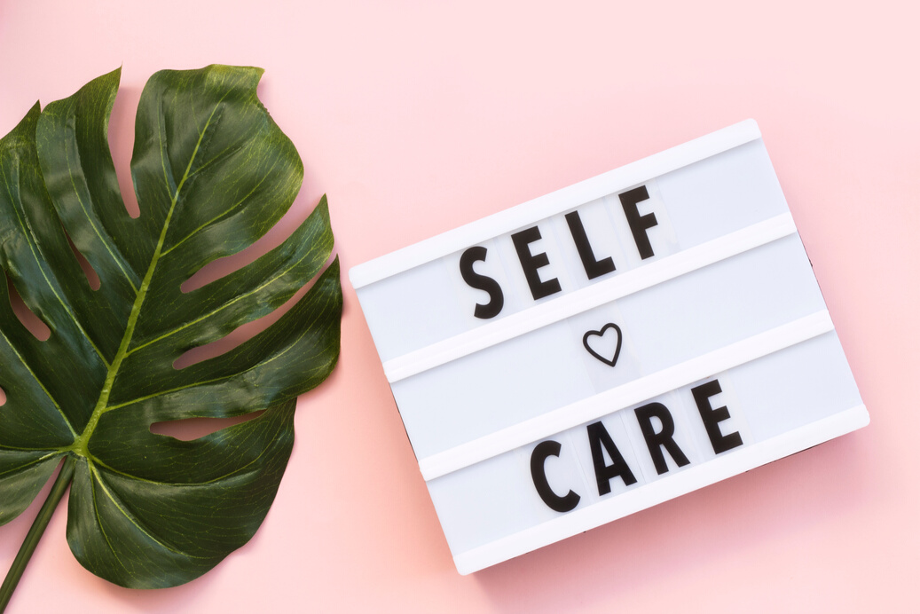 Self-care word on lightbox on pink background flat lay. Take care of yourself